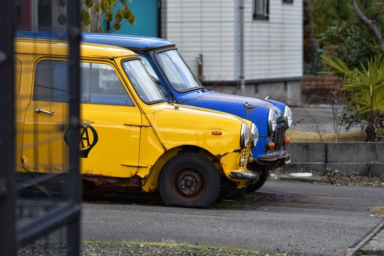 two old cars parked next to each other on the side of the road, mingei, one yellow and one blue eye, maintenance photo, high res photo, mini model