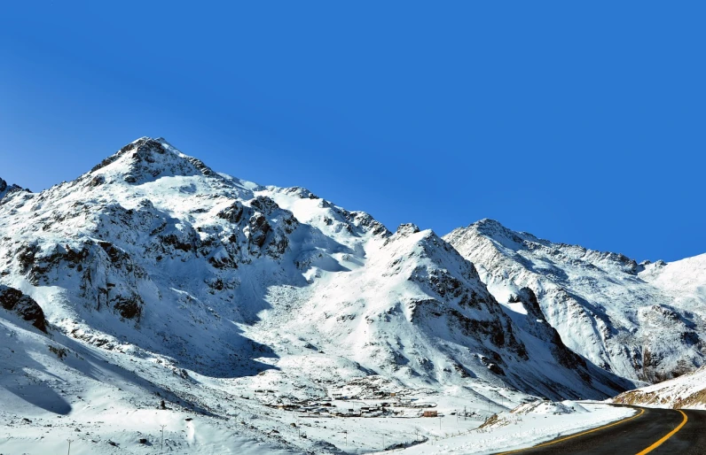 a mountain covered in snow next to a road, by Werner Andermatt, shutterstock, les nabis, morocco, view from bottom to top, panorama view, highly detailed photo