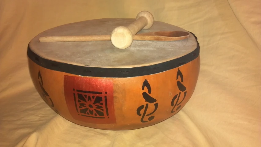 a drum with a wooden mallet on top of it, inspired by Shūbun Tenshō, hand painted, sahara, 8k!!, pumpkin