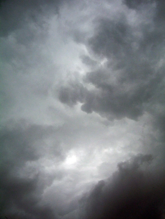 a plane is flying through a cloudy sky, a picture, by Alexander Scott, with overhead cloudy!!!!! skies, severe - looking, whorl. clouds, taken with a pentax1000