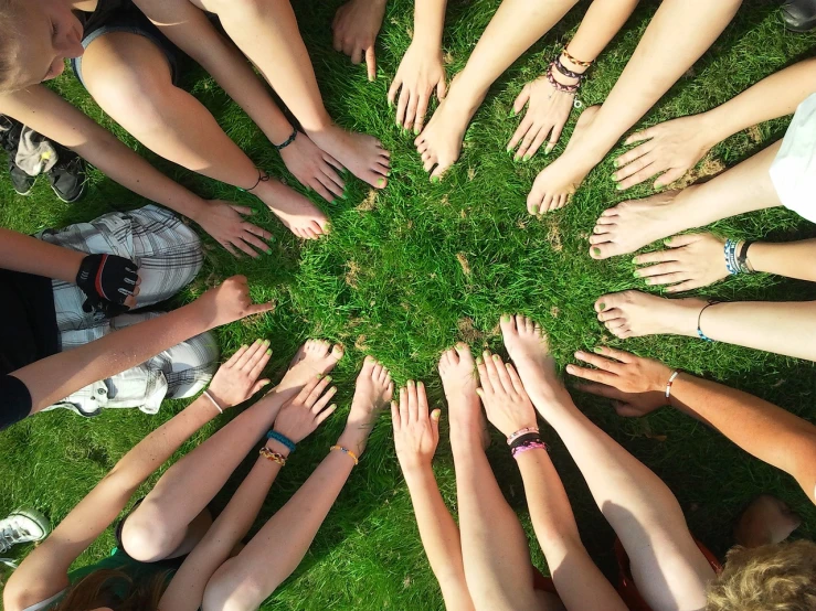 a group of people with their hands in a circle, a photo, grassy, !!natural beauty!!, groups of people, profile pic