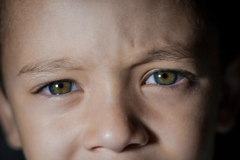 a close up of a child with a toothbrush in his mouth, incoherents, one green eye and one blue eye, fear and anger in their eyes, emerald green eyes, gazing dark brown eyes