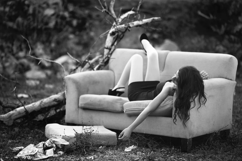 a black and white photo of a woman laying on a couch, by Lucia Peka, fine art, broken furniture, amidst nature, beautiful lonely girl, alexey gurylev