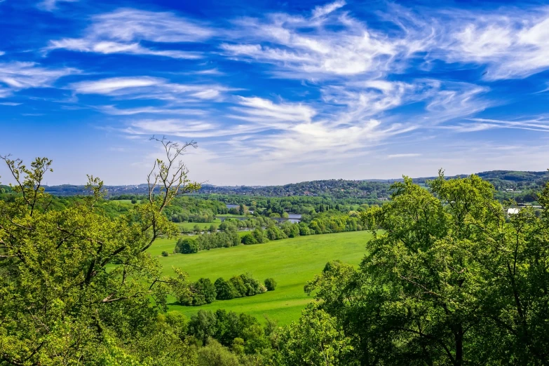 a view of the countryside from the top of a hill, a stock photo, renaissance, esher, green and blue colors, stunning nature in background, vibrant and vivid