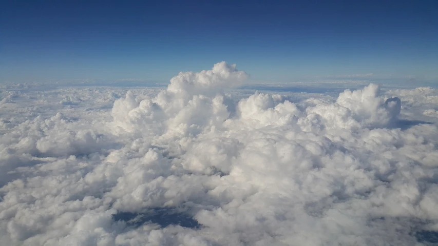 a blue sky filled with lots of white clouds, a picture, by Daniel Taylor, high above the ground, photo taken in 2018, high angle vertical, clouds outside the windows