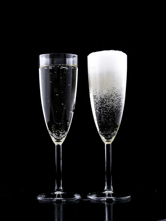 a couple of wine glasses sitting next to each other, by John Murdoch, lots of bubbles, on a black background, high res photo