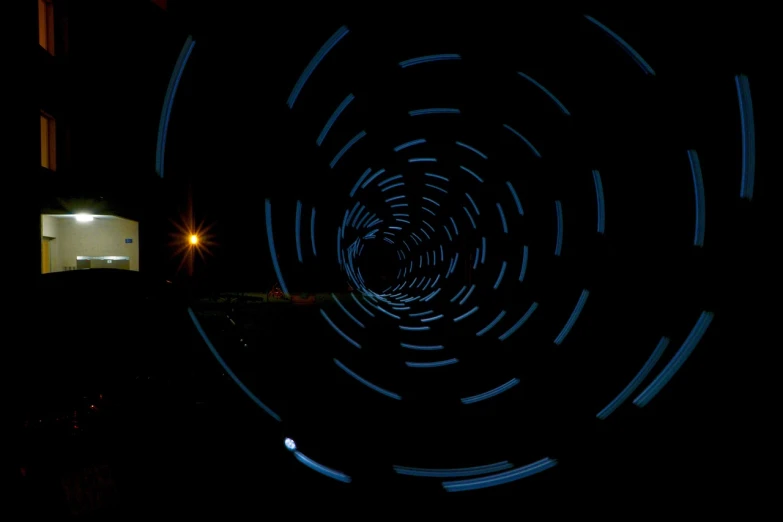 a blurry photo of a building at night, a picture, kinetic art, wormhole, circle, entrance to a dark tunnel, tracingstar trails