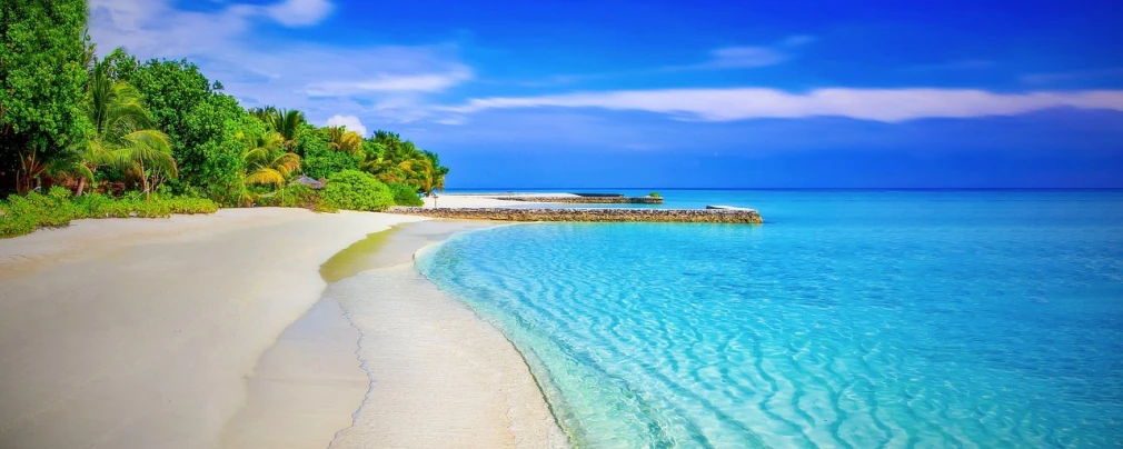 a sandy beach next to a body of water, a picture, beutiful, crystal clear blue water, rich blue colors, title