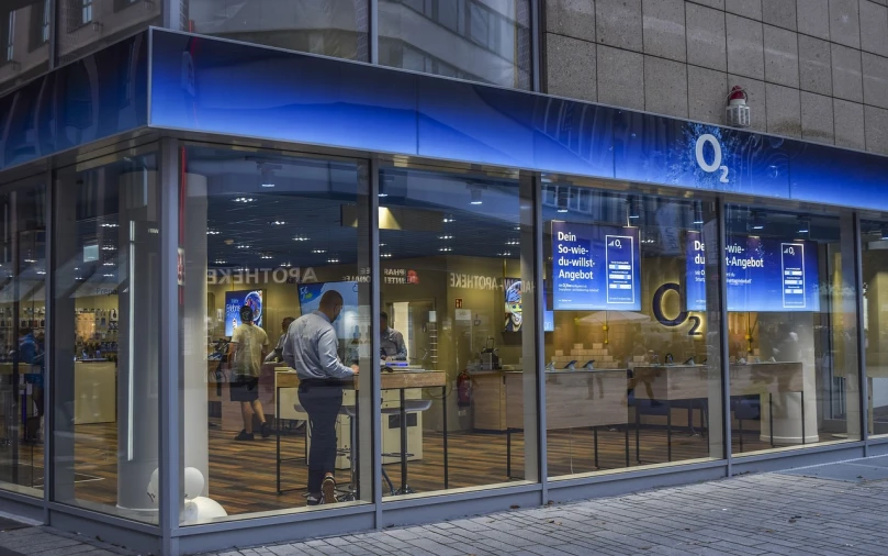 a man that is standing in front of a store, a photo, by Matt Cavotta, shutterstock, set in tokyo bank parking lot, golden and blue hour, the window is open, quebec