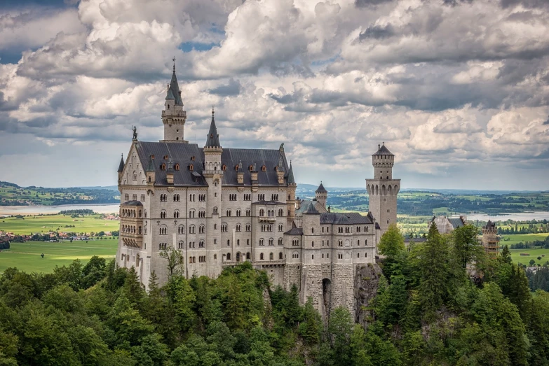 a castle sitting on top of a lush green hillside, by Oskar Lüthy, trending on pixabay, german renaissance architecture, disneyland castle, on a cloudy day, city of munich!!!