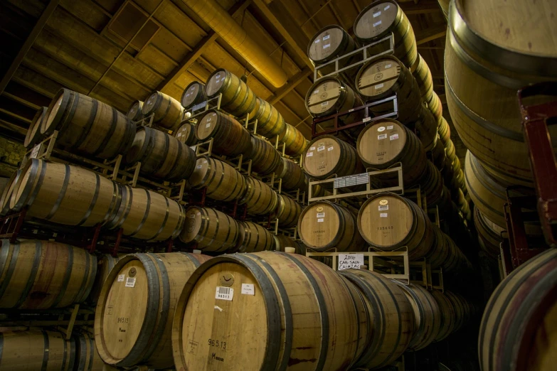 a room filled with lots of wooden barrels, by Robert Brackman, shutterstock, seattle, b - roll, a new, racks