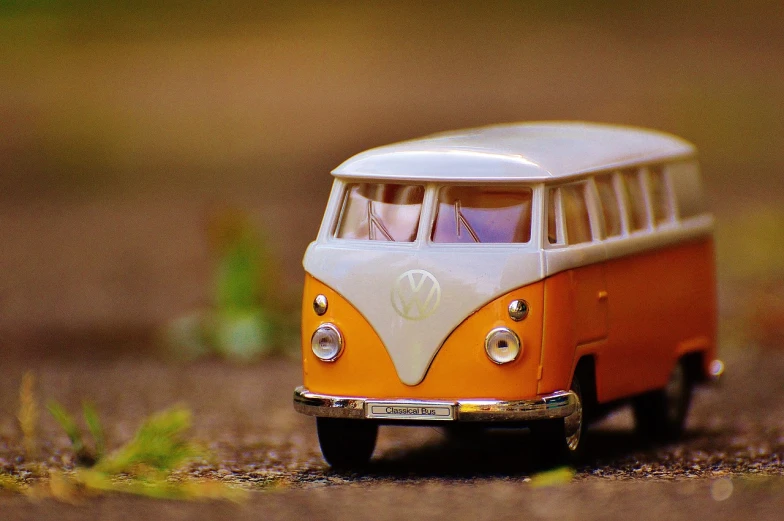 a toy vw bus is sitting on the ground, pixabay contest winner, orange tint, hyperrealistic flickr:5, cute future vehicles, photorealism. trending on flickr