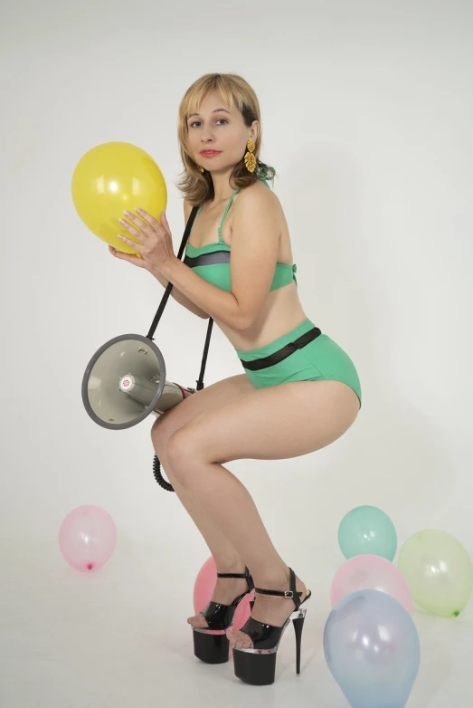 a woman in a green bikini holding a yellow balloon, a colorized photo, tumblr, figuration libre, in a photo studio, huge earrings and queer make up, wearing atsuko kudo latex outfit, retro 5 0 s style