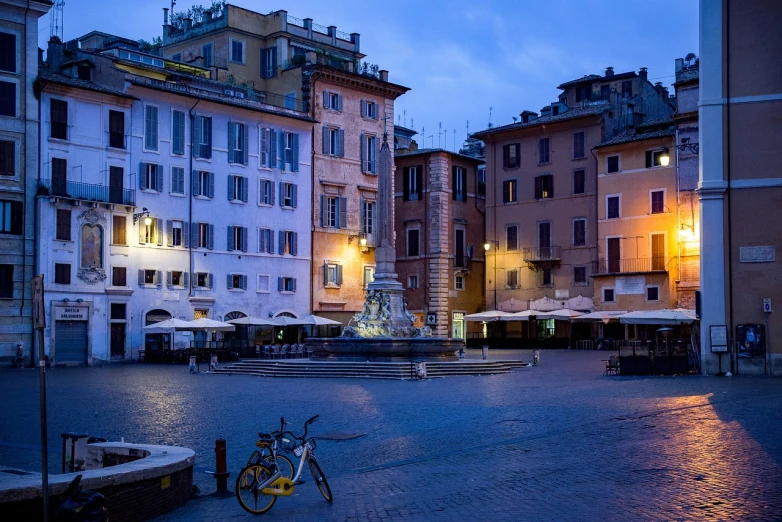 a bike is parked in front of a fountain, by Carlo Maderna, shutterstock, city street at dusk, market in ancient rome, sunken square, low-light