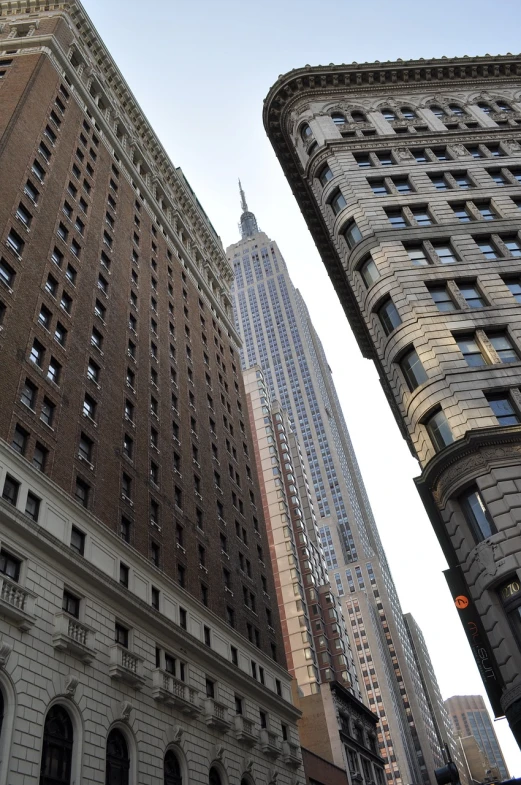 a very tall building towering over a city, by Robert Jacobsen, flickr, modernism, new york alleyway, empire state building, buildings carved out of stone, stock photo