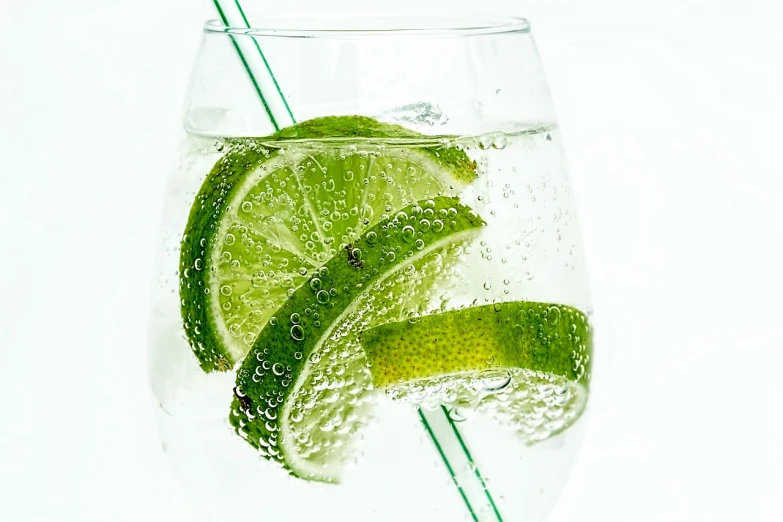 a glass of water with a slice of lime in it, by Matija Jama, pexels, photorealism, white background!!!!!!!!!!, with a straw, sparkling spirits, cool marketing photo