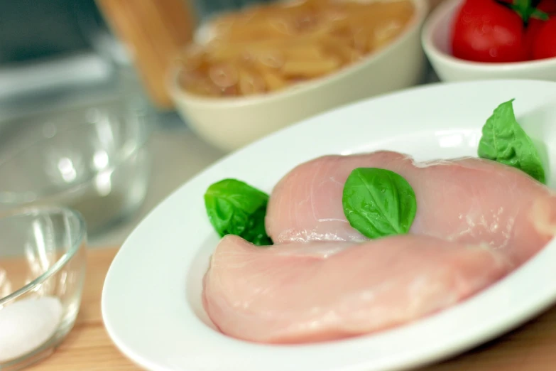 a close up of a plate of food on a table, shutterstock, renaissance, chicken feathers, filleting technique, 555400831, basil