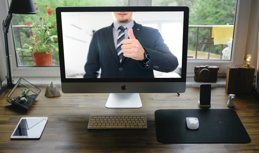 a man giving a thumbs up in front of a computer screen, by Robbie Trevino, wearing a stylish men's suit, shot on webcam, detailed photo of virtual world, hr