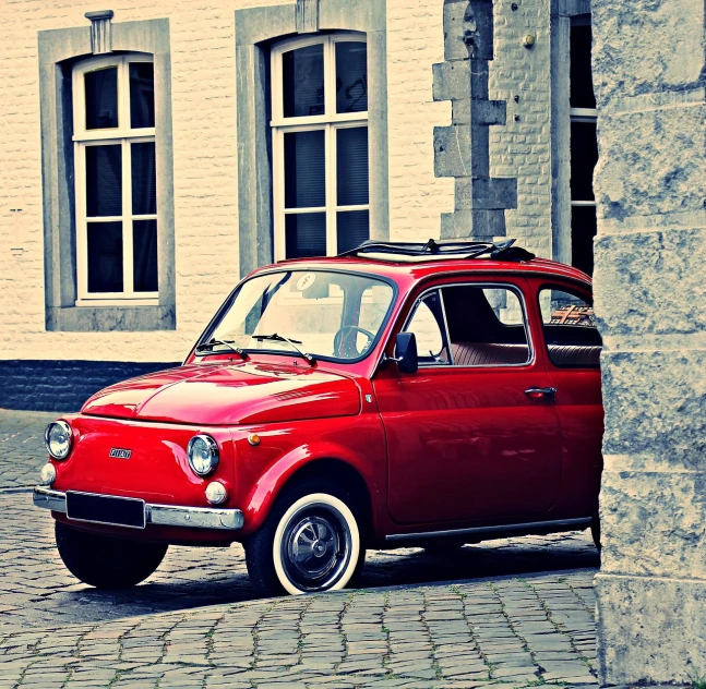 a small red car parked in front of a building, a photo, inspired by Romano Vio, trending on pixabay, renaissance, retro style ”, super adorable, liege, smokey
