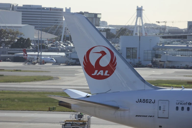 a large jetliner sitting on top of an airport tarmac, by Jakob Gauermann, shin hanga, japanese crane bird in center, tail fin, [ closeup ]!!, torii in the background