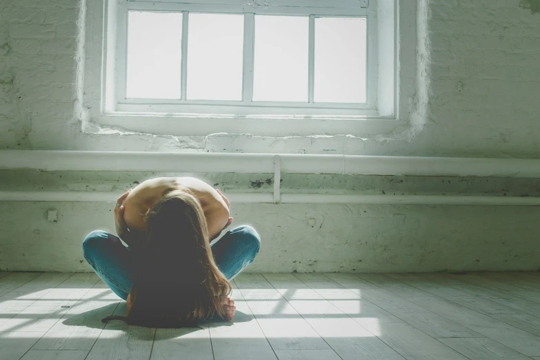 a woman sitting on the floor in front of a window, shutterstock, difraction from back light, depressed girl portrait, bare room, wide image