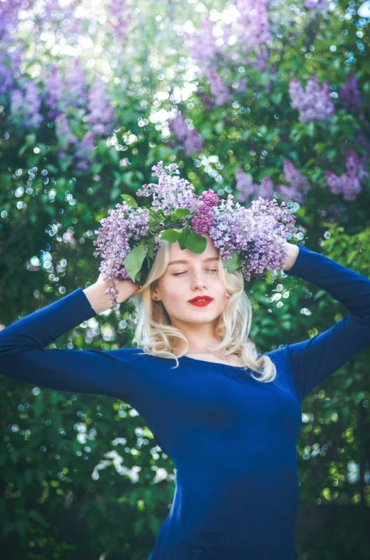 a woman with a wreath of flowers on her head, by Zofia Stryjenska, pexels, aestheticism, lilacs, blue clothes, blonde beautiful young woman, 🌸 🌼 💮