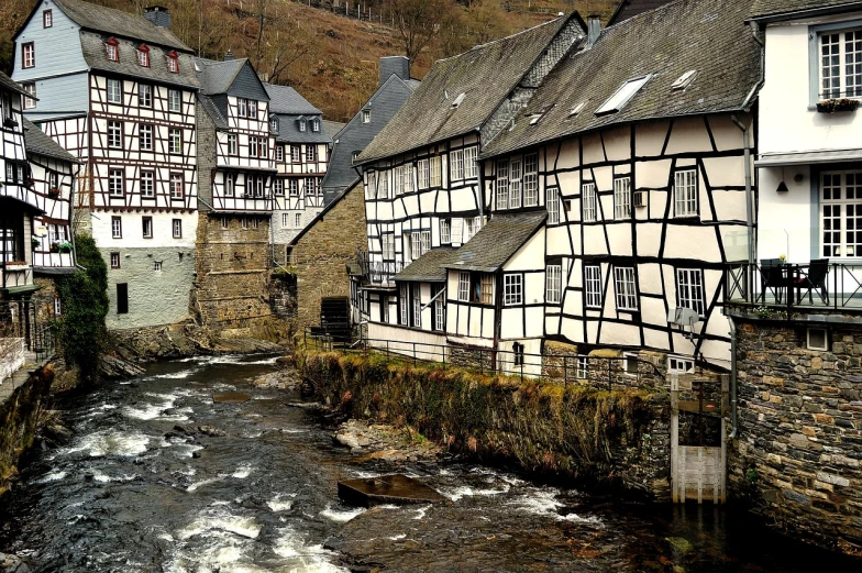 a river running through a town next to tall buildings, a photo, by Dietmar Damerau, flickr, renaissance, timbered house with bricks, marsden, germanic, shiny skin”