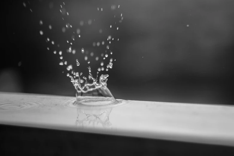 a black and white photo of a splash of water, a black and white photo, 4 k wallpaper, subtle depth of field, floating crown, sink