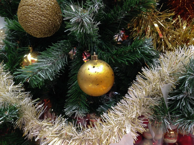 a close up of a christmas tree with ornaments, a photo, by Stefan Gierowski, realistic gold, sphere, phone photo, very accurate photo