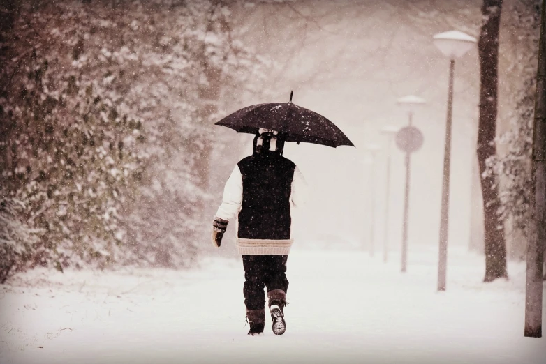 a person walking in the snow with an umbrella, a photo, 6 4 0, nuclear winter, student, hr