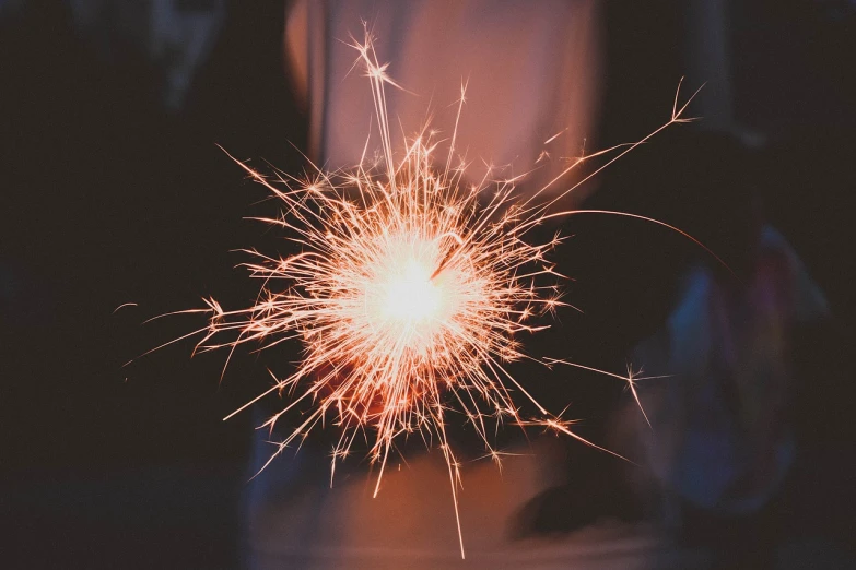 a close up of a person holding a sparkler, photo taken in 2018, istockphoto, celebrating a birthday, welding torches for arms