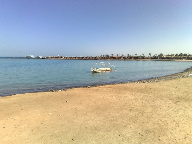 a boat sitting on top of a beach next to a body of water, a picture, by Ahmed Yacoubi, hurufiyya, sunny mid day, stepping stones, an amusement park in old egypt, calm sea