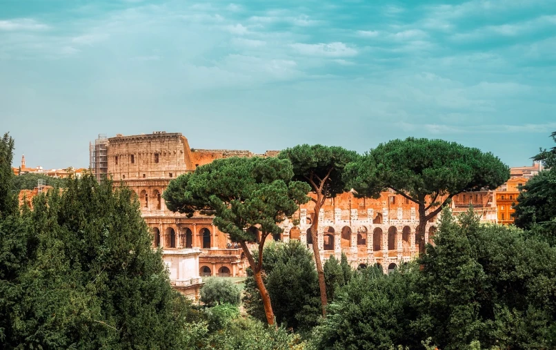 a large building with many trees in front of it, a tilt shift photo, by Pogus Caesar, shutterstock, neoclassicism, in the colosseum, background image, rich vivid vibrant colors, stock photo