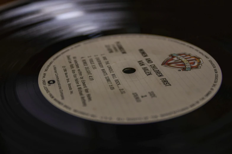 a record sitting on top of a wooden table, an album cover, by Mirko Rački, pexels, detailed close up shot, very detailed labeling, bob pepper, an old