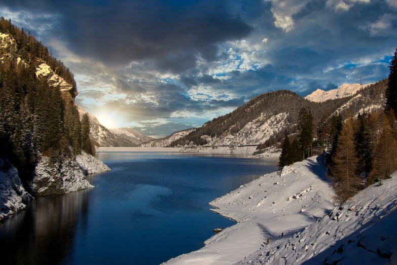 a large body of water surrounded by snow covered mountains, a photo, by Giuseppe Grisoni, renaissance, winter sun, water reservoir, tarski fiume, 8k photo