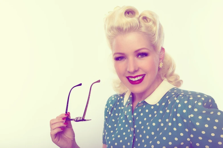 a woman holding up a pair of glasses, by Dan Luvisi, tumblr, 50s style infomercial, polkadots, piercing, a girl with blonde hair