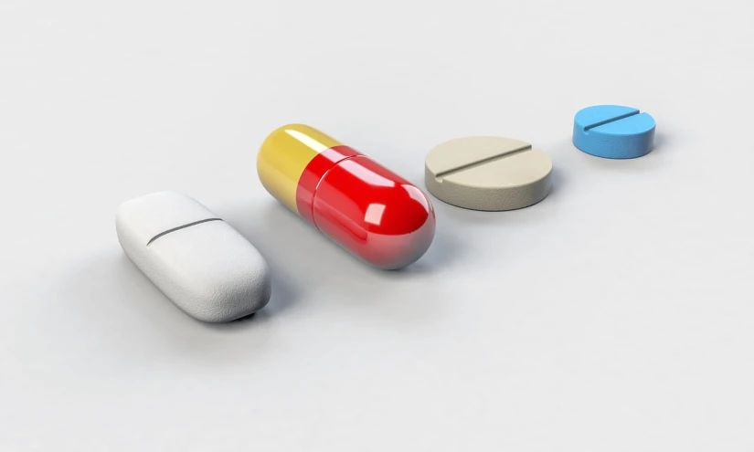 three pills sitting next to each other on a white surface, an illustration of, by Julian Allen, shutterstock, antipodeans, 3 d modeling, 4 colors, various scenarios, lined up horizontally