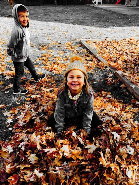 two children playing in a pile of leaves, a photo, tumblr, process art, big smile on her face, ((oversaturated)), sidney lugo, at the park