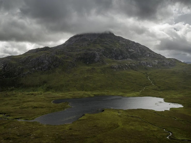 a mountain with a lake in the middle of it, by Eamon Everall, whealan, overcast skies, old gigachad with grey beard, sparsely populated
