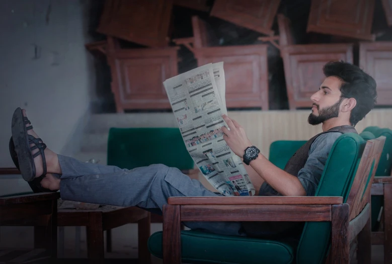 a man sitting in a chair reading a newspaper, a picture, by Ibrahim Kodra, trending on pexels, happening, model pose, omnious background, jayison devadas style, looking cute