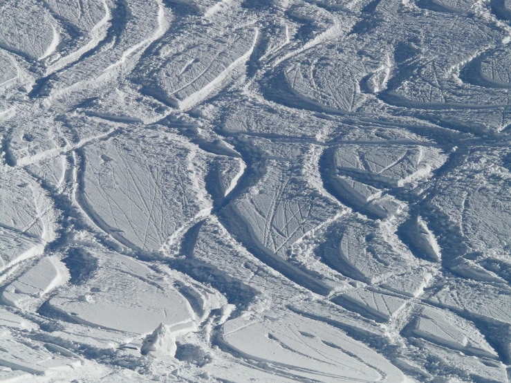 a man riding skis down a snow covered slope, a stipple, inspired by Vladimir Borovikovsky, flickr, intricate skin pattern texture, swirly ripples, lots of white cotton, seen from straight above