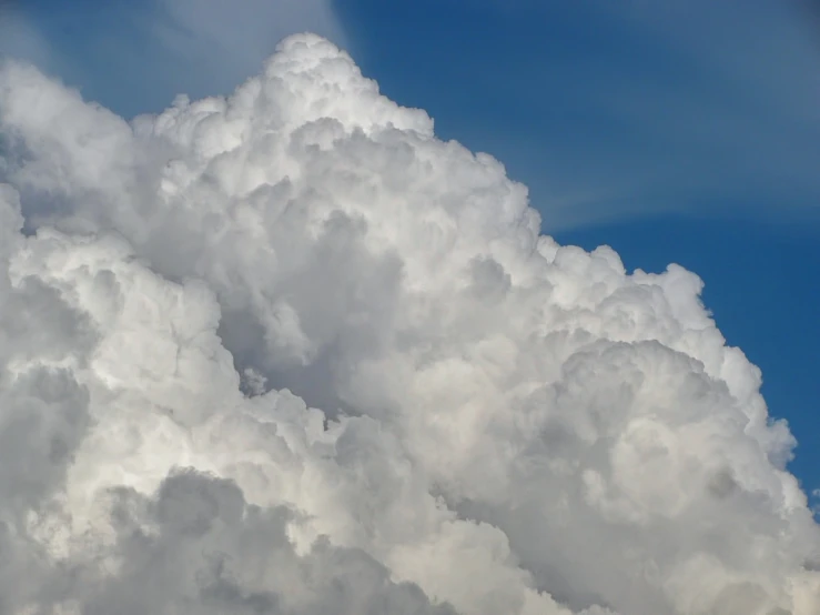 a plane flying through a cloud filled sky, by Tom Carapic, precisionism, towering cumulonimbus clouds, mid closeup, hyperdetailed!, big puffy clouds