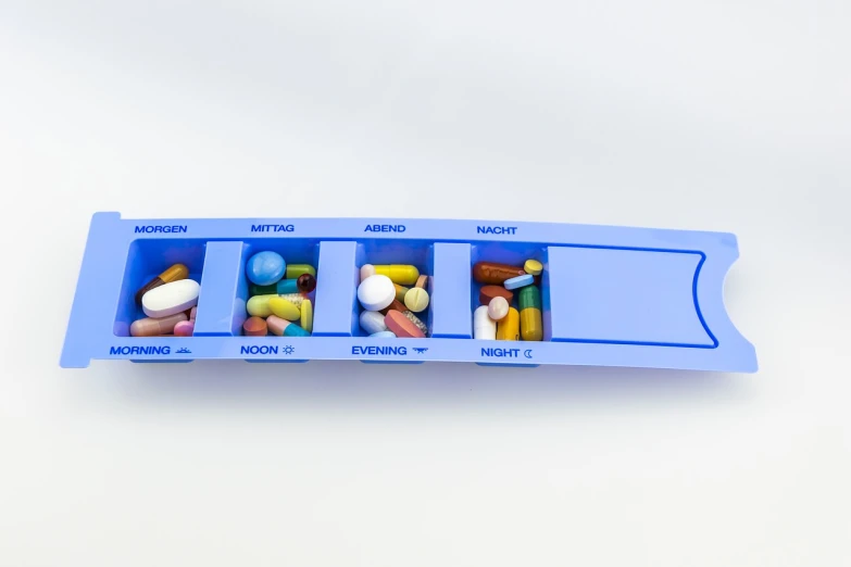 a pill tray filled with assorted pills, antipodeans, detailed product photo, half body photo, 5 - channel, blue period