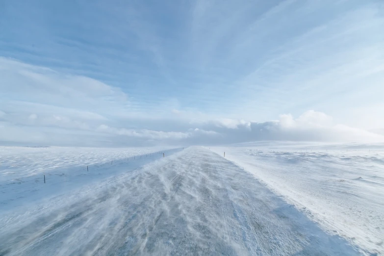 a man riding a snowboard down a snow covered slope, a picture, by Jesper Knudsen, pexels, romanticism, empty road in the middle, white sea cloud, david friedrich, very wide wide shot