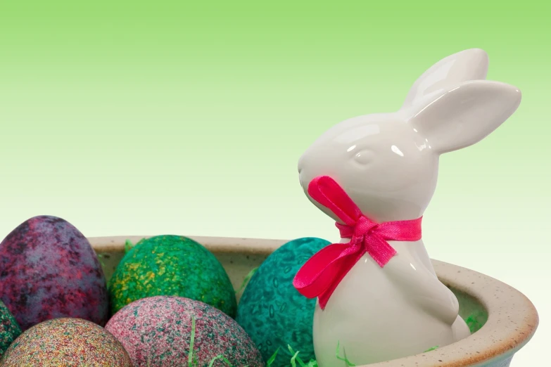 a white bunny figurine sitting in a bowl filled with easter eggs, a digital rendering, photo still, istockphoto, green and pink, 💋 💄 👠 👗