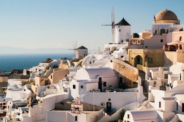 a number of buildings near a body of water, pexels, renaissance, in santorini island, very long shot of a windmill, istock, roofs