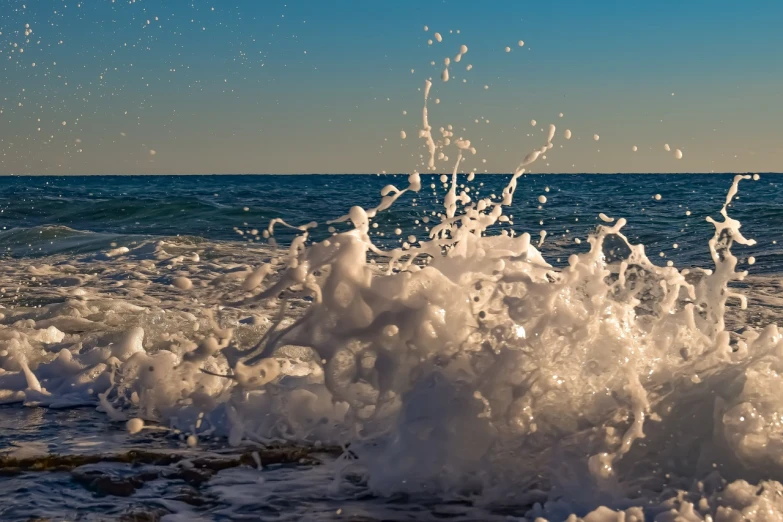 a person riding a surfboard on top of a wave, a picture, shutterstock, figuration libre, water splashing cascading, mediterranean beach background, wallpaper - 1 0 2 4, foamy bubbles