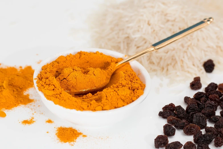 a close up of a bowl of food with raisins, inspired by Slava Raškaj, pexels, antipodeans, yellow and ornage color scheme, vibrant powder paints, rice, hairy orange body