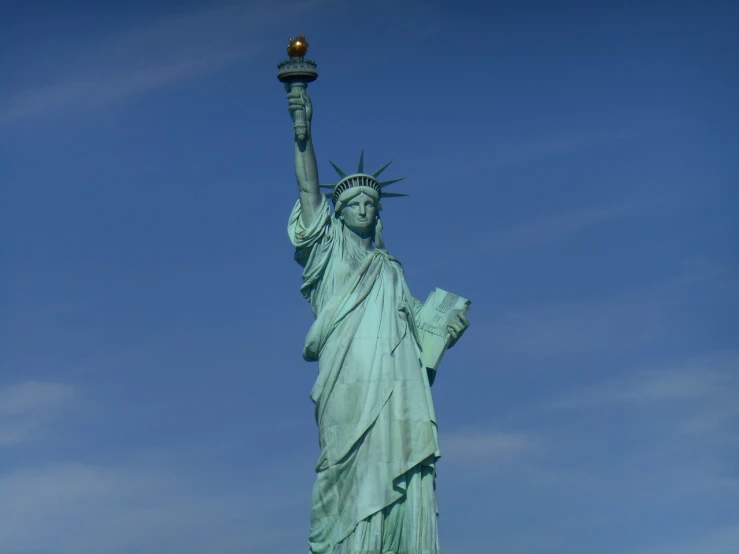 a statue of liberty holding a lit candle, a statue, figuration libre, blue sky, wide shot photo, mid shot photo, very detailed!