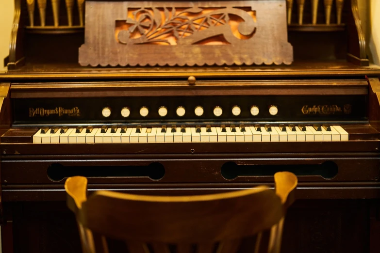 a close up of a piano with a chair in front of it, inspired by Bryan Organ, carved in wood, warmly lit, radio, worship